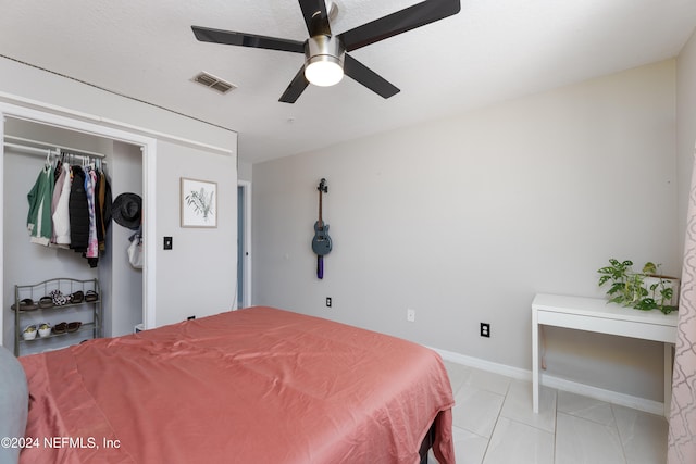 bedroom featuring ceiling fan, light tile patterned floors, and a closet