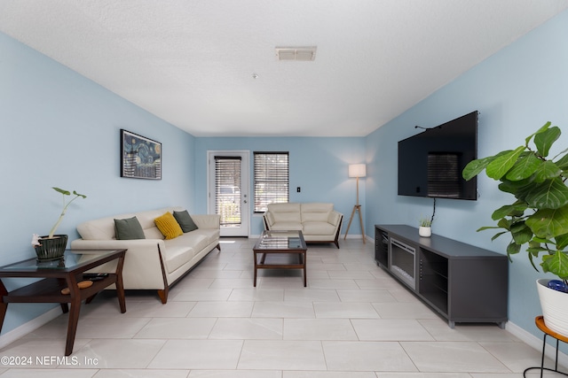 tiled living room with a textured ceiling