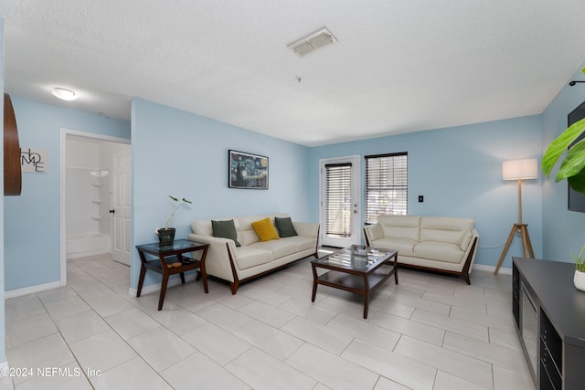 tiled living room with a textured ceiling