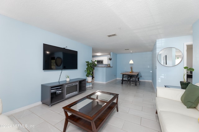 living room featuring light tile patterned floors and a textured ceiling