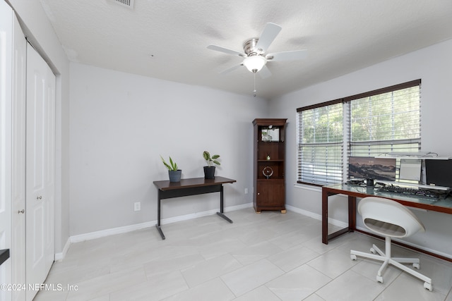 office area with light tile patterned floors, a textured ceiling, and ceiling fan