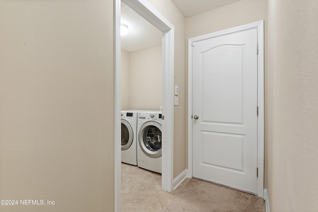 laundry area featuring washing machine and dryer and a textured ceiling