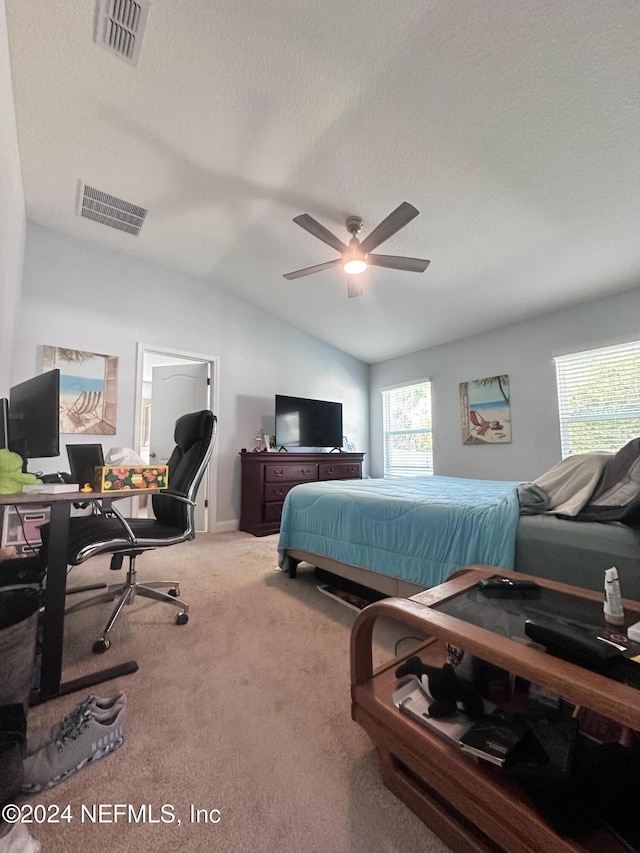 carpeted bedroom featuring a textured ceiling, vaulted ceiling, and ceiling fan