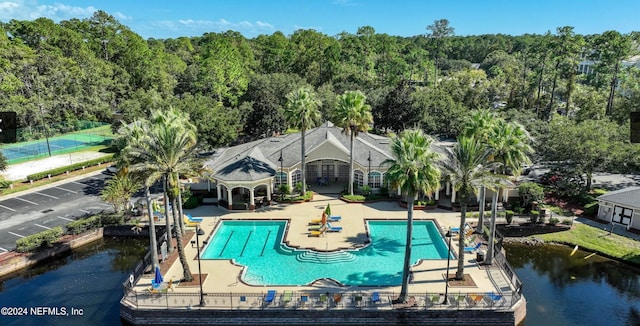 view of pool featuring a water view and a patio area