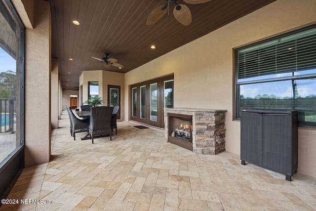 view of patio / terrace with ceiling fan and an outdoor stone fireplace