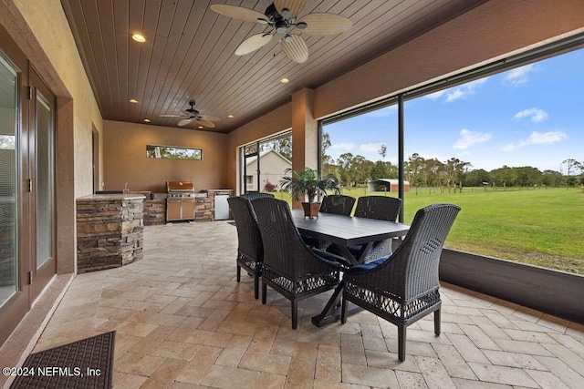 sunroom with ceiling fan and wooden ceiling