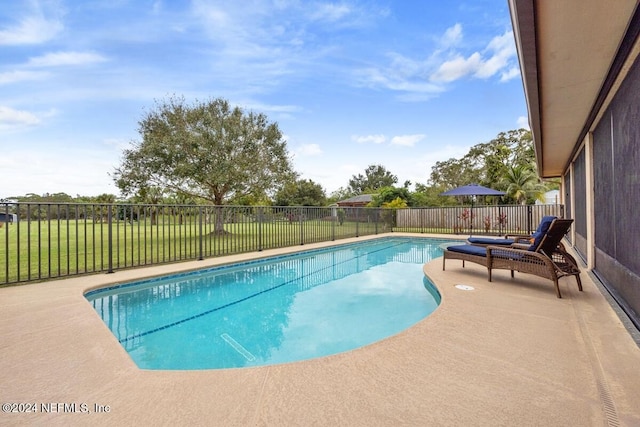 view of swimming pool featuring a yard and a patio