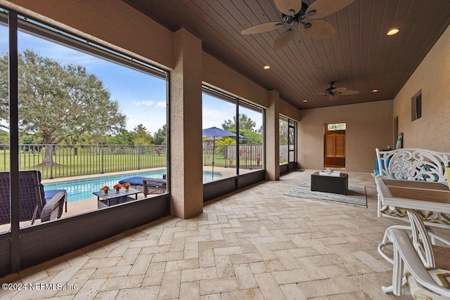 sunroom with ceiling fan and wooden ceiling