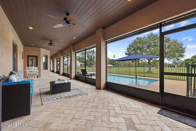 unfurnished sunroom featuring ceiling fan and wood ceiling