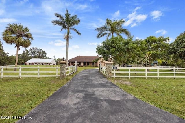 view of front of property with a rural view and a front lawn