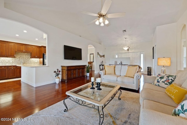 living room featuring ceiling fan, sink, and dark wood-type flooring