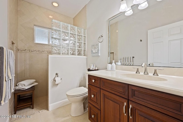 bathroom featuring tiled shower, vanity, tile patterned floors, and toilet