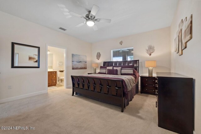 bedroom featuring ensuite bath, ceiling fan, and light carpet