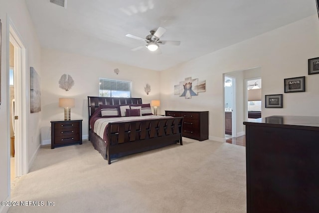 carpeted bedroom with ensuite bathroom and ceiling fan