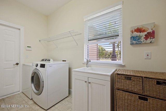 laundry area with cabinets, washing machine and dryer, light tile patterned floors, and sink