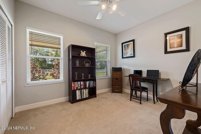 carpeted home office featuring ceiling fan