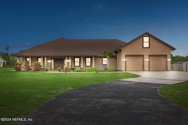 view of front of house with a garage and a lawn