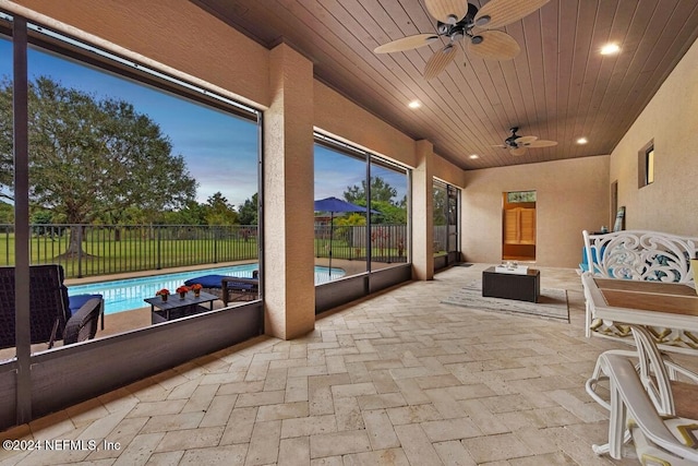 sunroom featuring ceiling fan and wooden ceiling