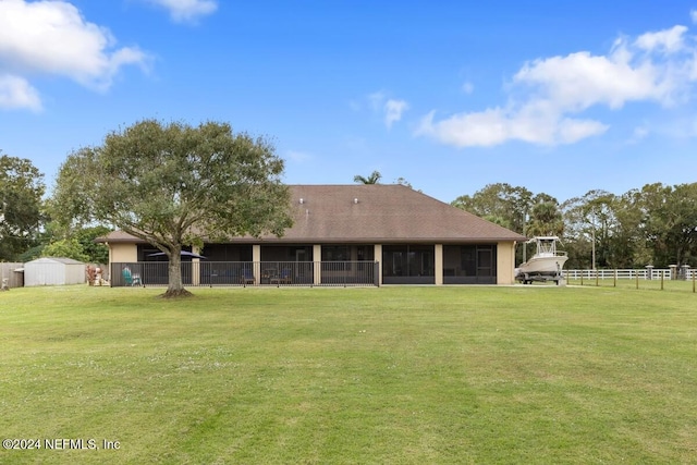 rear view of property with a storage shed and a yard