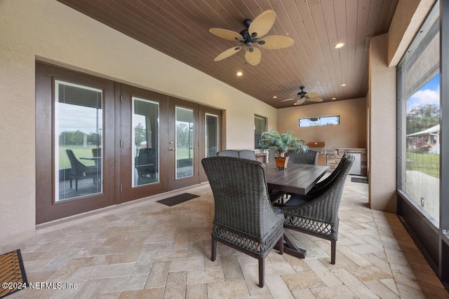 sunroom with ceiling fan and wood ceiling