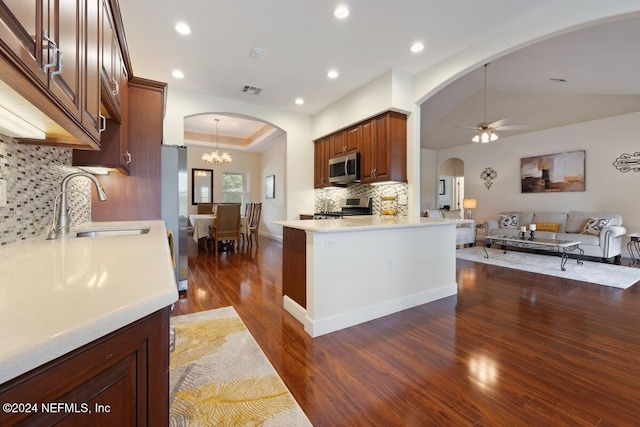 kitchen with sink, vaulted ceiling, dark hardwood / wood-style floors, decorative backsplash, and appliances with stainless steel finishes