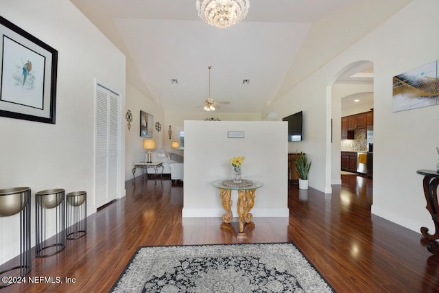 hall with dark hardwood / wood-style floors, vaulted ceiling, and an inviting chandelier