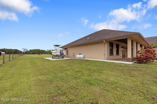 back of property with a yard and a patio