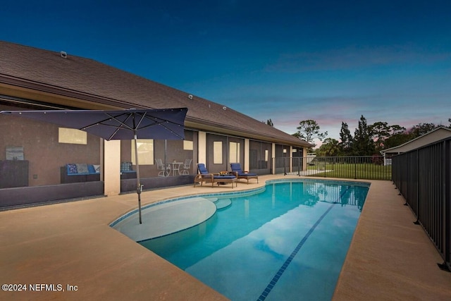 pool at dusk featuring a patio