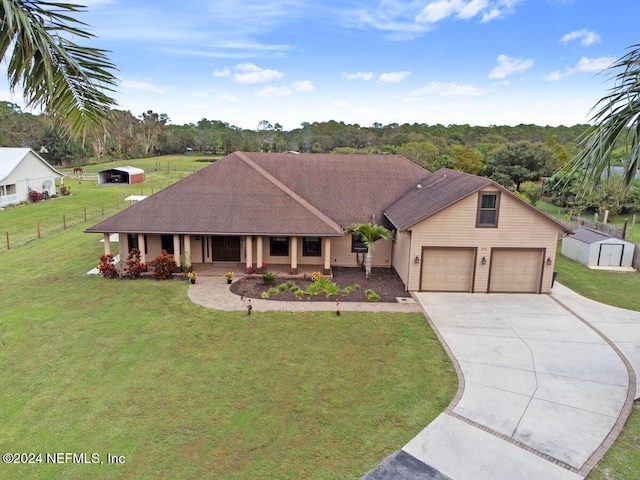 view of front of house featuring covered porch, a front yard, and a storage unit