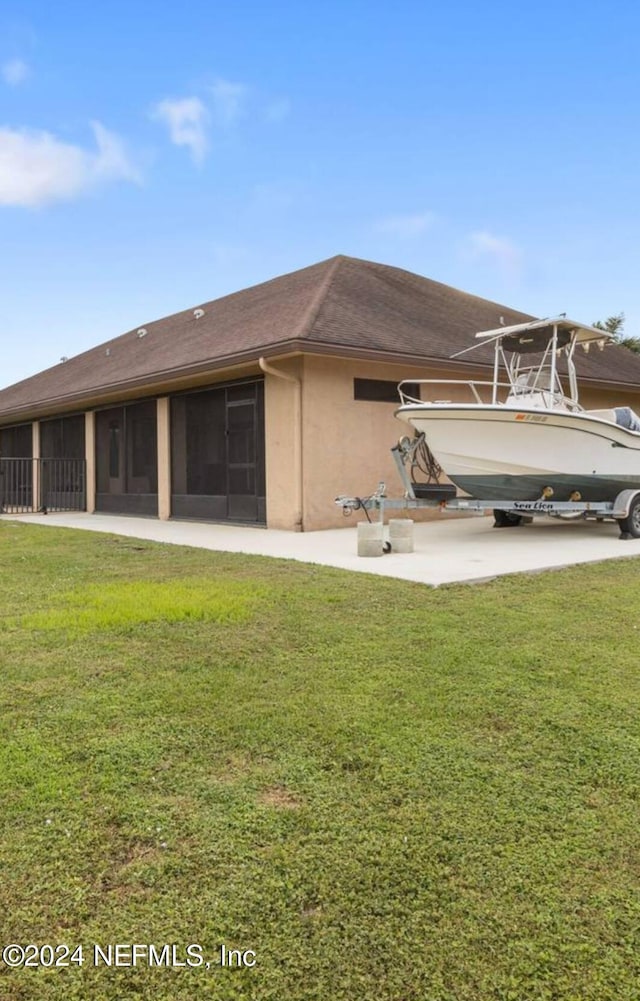 back of property featuring a sunroom and a yard