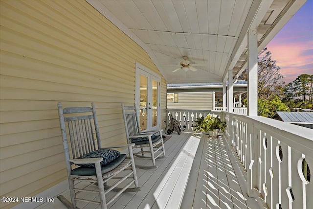 deck at dusk with french doors and ceiling fan