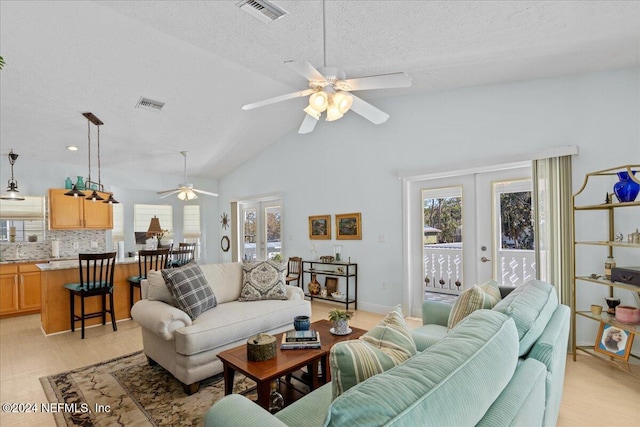 living room with ceiling fan, french doors, a textured ceiling, and light hardwood / wood-style flooring