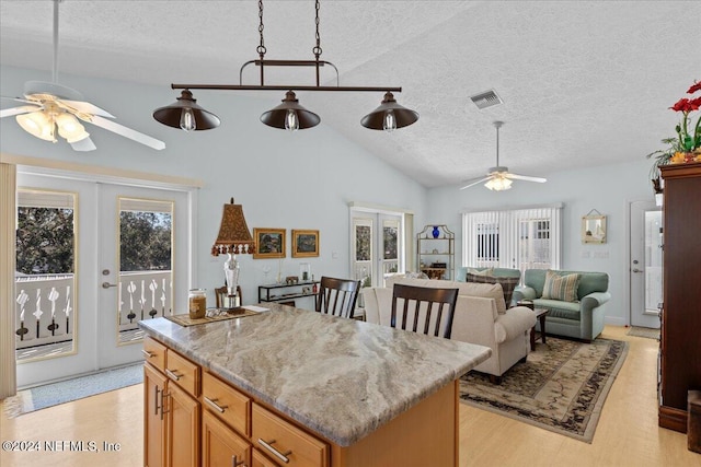 kitchen featuring ceiling fan, vaulted ceiling, a textured ceiling, and french doors