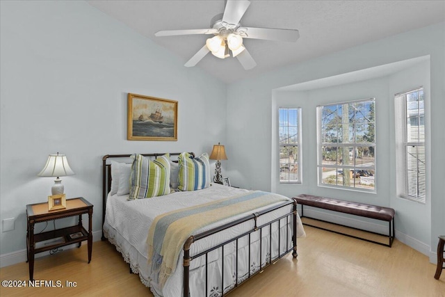 bedroom featuring light wood-type flooring, ceiling fan, and lofted ceiling