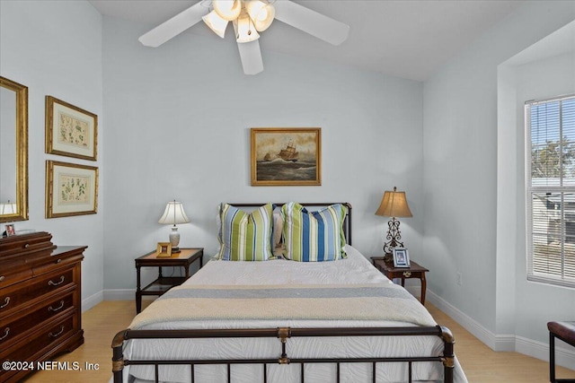 bedroom with ceiling fan, light hardwood / wood-style floors, and lofted ceiling