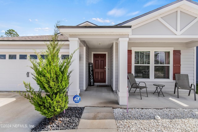 property entrance with covered porch and a garage