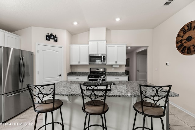 kitchen with white cabinetry, stainless steel appliances, and a kitchen island with sink