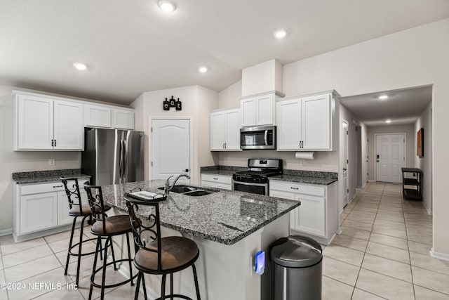 kitchen featuring white cabinets, appliances with stainless steel finishes, and an island with sink