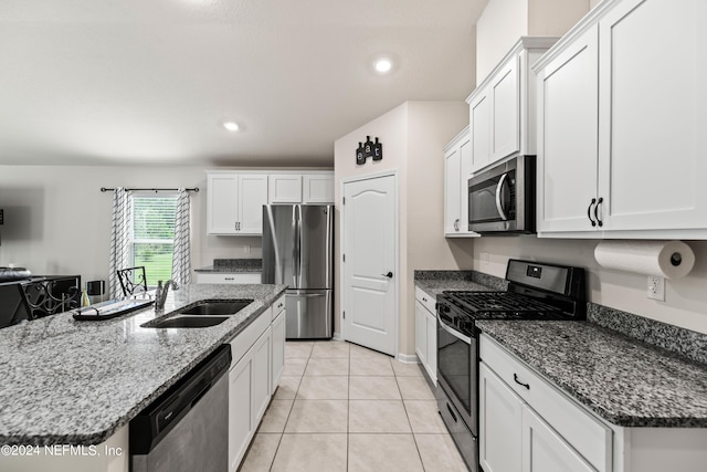 kitchen with white cabinetry, sink, dark stone counters, and appliances with stainless steel finishes