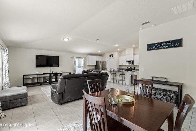 tiled dining room with lofted ceiling