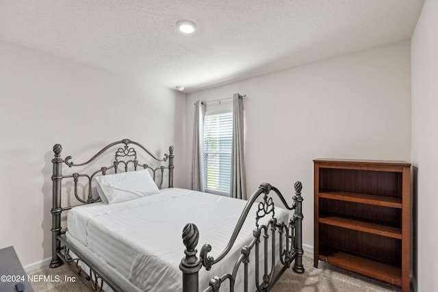 bedroom with carpet and a textured ceiling