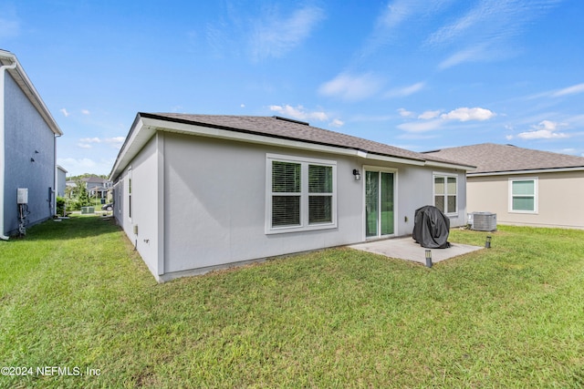 back of property featuring central AC, a patio area, and a yard