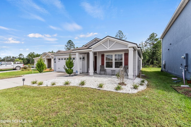 view of front of property with a front yard, a garage, and covered porch