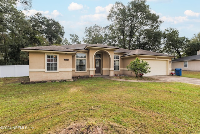 view of front of property featuring a front yard and a garage