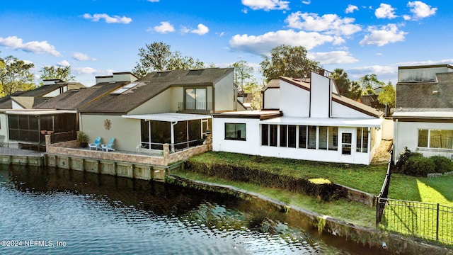 rear view of house featuring a water view