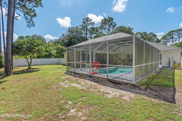 view of yard with a fenced in pool, glass enclosure, and a patio area