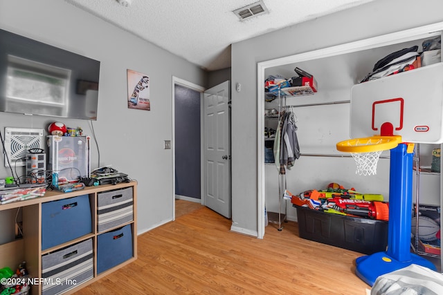 rec room with wood-type flooring and a textured ceiling