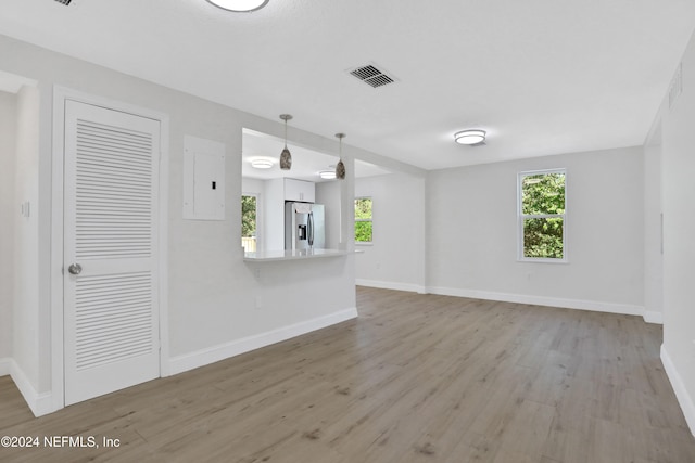 unfurnished living room featuring light hardwood / wood-style floors and electric panel