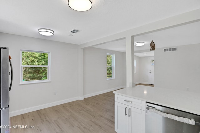 kitchen featuring white cabinets, a healthy amount of sunlight, light wood-type flooring, and stainless steel appliances