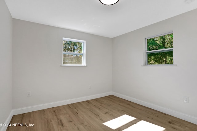 empty room with light hardwood / wood-style flooring and a healthy amount of sunlight